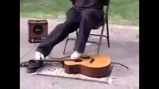 Парень играет на гитаре ногами