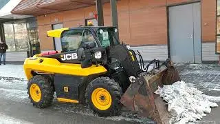 Cleaning of snow and ice from the road and sidewalk with a JCB loader (part 1)