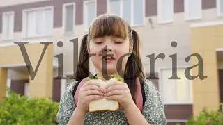 little girl with school backpack eats sandwich at recess school yard. children's snack school break