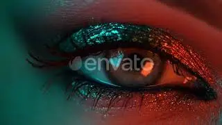 Extreme Close Up of Human Eye Iris Under Neon Light. Female with Beautiful Makeup, Glitter Shado...