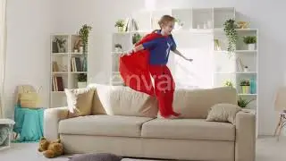 Superheroine Girl Jumping on Sofa Laughing | Stock Footage - Envato elements