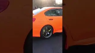 Bright satin orange wrx STI that will leave you blind at cars and coffee