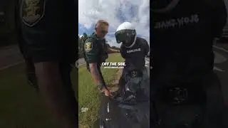 Officer handcuffs a biker in the middle of the road 