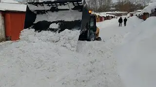 Pushing out heavy snow with JCB compact telescopic loader