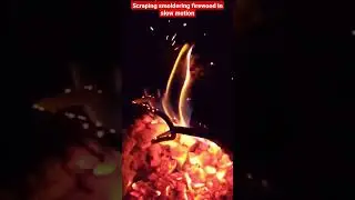 scraping smoldering fire wood in slow motion