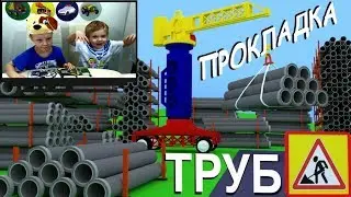 Автокран, экскаватор и самосвал работают вместе, прокладывая трубы к дому.