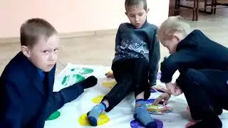 Дети в библиотеке играют в Твистер.