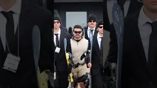 Security guards protect man snowboarding