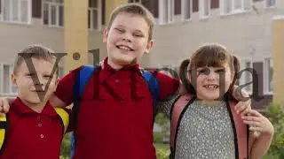 child schoolchildren hugging smiling school yard. Portrait happy students with backpacks outside