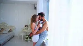 Quiet Morning Loving Couple in Bedroom Next to Bed Light on Background of Table Decoration and
