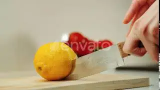 Hands with Knife Cutting Lemon on the Kitchen Board | Stock Footage - Envato elements