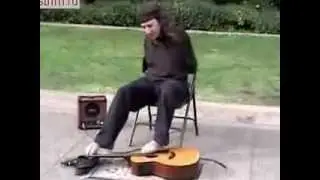Парень играет ногами на гитаре