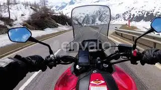 Motorcyclist Rides on a Beautiful Landscape Snowy Mountain Road Near Swiss Alps. Switzerland | S...