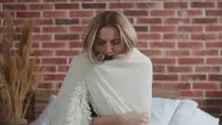 Woman wrapped in a blanket shivering while sick | Stock Footage Video | Royalty Free