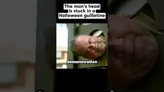 The man's head is stuck in a Halloween guillotine 