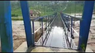 robohnya bangunan di samping jembatan biru