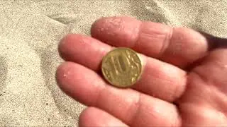 Searching for coins on the beach with a metal detector