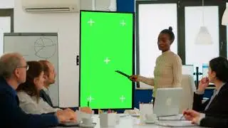 Woman in office with green screen monitor