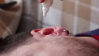 No Copyright Person applying ear drops  to a mans ear | Stock Footage Video