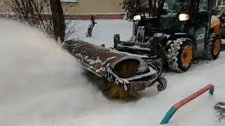 Cleaning the yard area from snow with a brush