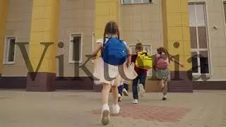 little children run school school yard. view from back. child boys girls running with school